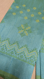 Angled side view of blue kasuti blouse showing kasuti stitchwork